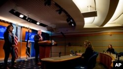 Secretary of State Mike Pompeo, accompanied by State Department spokeswoman Morgan Ortagus, left, speaks at a news conference at the State Department, April 29, 2020, in Washington.