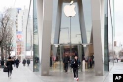 Customers leave the Apple store in the Brooklyn borough of New York, Jan. 3, 2019.