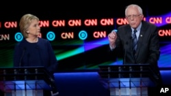 FILE - Democratic presidential candidates Hillary Clinton and Senator Bernie Sanders are seen during a presidential primary debate at the University of Michigan-Flint, March 6, 2016, in Flint, Michigan.