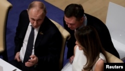 Президент Путін поруч з Меланією Трамп на вечері у Гамбурзі 7 липня.