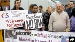Refugee supporters look on after Abdisellam Hassen Ahmed, a Somali refugee who had been stuck in limbo after President Donald Trump temporarily banned refugee entries, arrival at Salt Lake International Airport, in Salt Lake City, Feb. 10, 2017. 