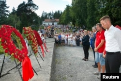 FILE - From left, Norway's Prime Minister Erna Solberg, Labor Party leader Jonas Gahr Stoere, National Support Group's leader Trond Henry Blattmann and leader of Labor Youth of Norway (AUF) Eskil Pedersen lay wreaths on Utoya Island, July 22, 2014.