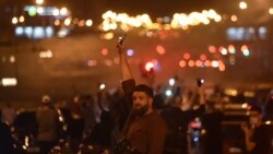 FILE - A man holds up a phone with its flashlight on during a rally of opposition supporters, who accuse Belarusian President Alexander Lukashenko of rigging the polls in his favor, in Minsk, Belarus, Aug. 10, 2020.