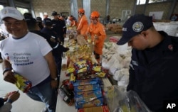 Venezuelan volunteers, Colombian firefighters and rescue workers prepare USAID humanitarian aid for storage at a warehouse next to the Tienditas International Bridge, near Cucuta, Colombia, on the border with Venezuela, Feb. 8, 2019.