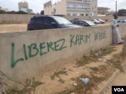 A spray-painted message reads "Free Karim" and is a common sight Sengalese capital as the corruption trial of Karim Wade continues, Nov. 11, 2014. (Christin Roby/VOA)