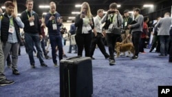 Attendees take pictures of ForwardX Robotics' CX-1 self-driving luggage during CES Unveiled at CES International Sunday, Jan. 7, 2018, in Las Vegas. (AP Photo/Jae C. Hong)