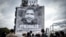 People attend the installation of a tarp depicting jailed Algerian journalist Khaled Drareni by French street artist and painter Christian Guemy, aka C215, in Paris, Oct. 15, 2020.
