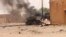 FILE - Smoke and flames ascend from an army armored vehicle in Gao, northwestern Mali, following an explosion on July 1, 2018.