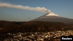 Una nube de cenizas y vapor emerge del volcán Popocatépetl se observa en esta foto desde el poblado de Santiago Xalizintla, en México, el 12 de mayo de 2023.