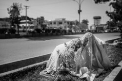 Drug users in Afghanistan often cover their heads with scarfs to better inhale the fumes. (Maciej Stanik/VOA)