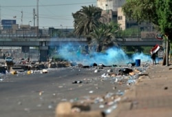 Iraqi security forces fire tear gas while anti-government protesters gather for a demonstration in Baghdad, Iraq, Oct. 4, 2019.