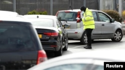 People queue in their cars at an NHS drive through coronavirus disease (COVID-19) testing facility in the car park of Ikea in Wembley, Britain, April 1, 2020.