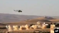 This citizen journalist image provided by Shaam News Network purports to show a helicopter gunship flying a bombing run in al-Qalmoun, Syria, July 24, 2012.