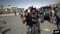 Một người bị thương đang được đưa ra khỏi nơi bị tấn công ở một trạm cảnh sát ở Kabul, ngày 18 tháng 6, 2011