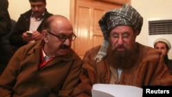 Maulana Sami ul-Haq (kanan), salah seorang juru runding Taliban dan Irfan Siddiqui, perwakilan dari emerintah Pakistan mendiskusikan pernyataan bersama sebelum menggelar konferensi pers di Islamabad, Pakistan, 6 Februari 2014 (Foto: dok).