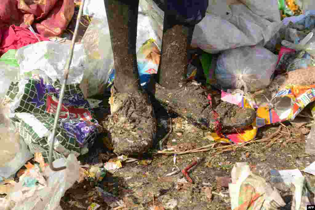 Seorang perempuan pemulung India mengumpulkan barang-barang yang bisa didaur ulang di tempat pembungan sampah di pinggiran Hyderabad.
