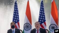 U.S. Secretary of State Mike Pompeo, right, speaks with Secretary of Defence Mark Esper seated beside him during a joint press conference with their Indian counterparts at Hyderabad House in New Delhi, India, Oct. 27, 2020.