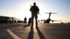 FILE - A solider stands guard near a military aircraft in Kandahar, Afghanistan.