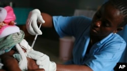 FILE - A child is vaccinated during a malaria vaccine trial in Bagamoyo, Tanzania, Aug. 2007.