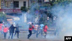 Demonstran kocar-kacir setelah polisi Turki menembakkan meriam air dan gas air mata di distrik Okmeydani, Istanbul (22/5). (AFP/Ozan Kose)