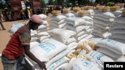 FILE - A man carries sacks of food aid delivered by the United Nations Office for the Coordination of Humanitarian Affairs and world food program in the village of Makunzi Wali, Central African Republic, April 27, 2017.