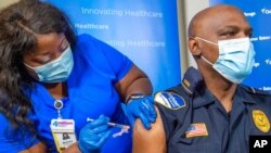 Lt. Ollie Martin, right, with Ochsner Security, is inoculated with the Pfizer-BioNTech COVID-19 vaccine by nurse Meshoca Williams at Ochsner Hospital on O'Neal Lane, in Baton Rouge, La., Dec. 15, 2020.