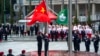 In this photo released by Xinhua News Agency, policemen perform a flag-raising ceremony in Macao, Dec. 20, 2021, marking the 22nd anniversary of the former Portuguese colony's handover to Chinese rule. 