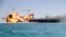 In this picture released by the Iranian Tasnim news agency on Feb. 25, 2015, a replica of a U.S. aircraft carrier is exploded by the Revolutionary Guard's speedboats during large-scale naval drills near the entrance of the Persian Gulf, Iran.