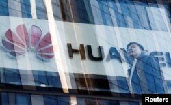 FILE - A man walks past a Huawei shop in Beijing, China, March 7, 2019.