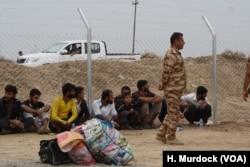 Men arrive wearing beards and shortened trousers at the Khazir Camp in the Kurdish region of northern Iraq as Islamic State dictated in their village, Oct. 28, 2016.