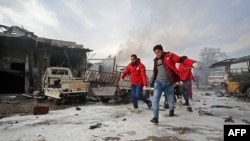 FILE - Syrian paramedics carry away on a stretcher a wounded man following a regime air strike on a vegetable market in Syria's last major opposition bastion of Idlib, Jan. 15, 2020. 