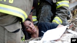 A woman is pulled out from under tornado debris at the Plaza Towers School in Moore, Oklahoma, May 20, 2013. 