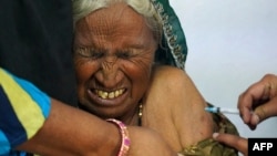 An elderly woman reacts as she is inoculated with the COVID-19 coronavirus vaccine at a government hospital on the outskirts of Ajmer, India, on March 6, 2021.