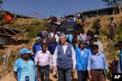FILE - United Nations High Commissioner for Refugees Filippo Grandi, center, visits newly arrived Rohingya Muslims at Kutupalong refugee camp, Bangladesh, Sept. 23, 2017.