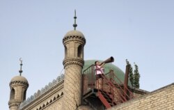 FILE - An imam calls Uighur Muslims for afternoon prayer in China's Xinjiang region, in 2012.
