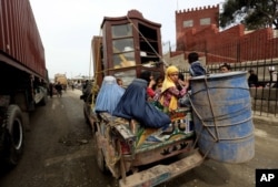 FILE - An Afghan refugee family returns to Afghanistan through Pakistan's border crossing, Torkham, east of Kabul, Afghanistan, March 11, 2015.