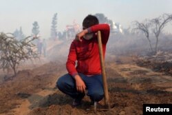A volunteer takes a break from battling wildfires in Portezuelo, Chile, Jan. 30, 2017.