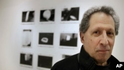 Photographer Karl Baden of Cambridge, Massachusetts, stands for a photo in front of an exhibit of his photographs from 1976 called "Thermographs" at the Miller Yezerski Gallery in Boston, Feb. 22, 2017.