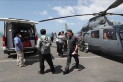 Medical officers prepare a sample for loading on to a helicopter for testing in Sihanoukville, Cambodia, Feb. 13, 2020. The Westerdam cruise ship anchored Thursday off Cambodia for health checks on its 2,200 passengers and crew.