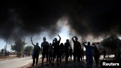 Masyarakat dari kelompok kurang mampu meneriakkan slogan-slogan memprotes minimnya bantuan dari pemerintah dalam masa karantina wilayah di tengah wabah virus corona (Covid-19) di Santiago, Chili, 25 Mei 2020. (Foto: Reuters)