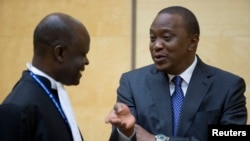 Kenya's President Uhuru Kenyatta (R) speaks to a member of his defense team as he appears before the International Criminal Court at The Hague, Oct. 8, 2014.