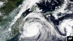 This Sept. 1, 2020, satellite image released by NASA shows Typhoon Maysak over Japan's southernmost islands, including Okinawa, center. 