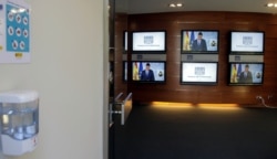 FILE - Spanish Prime Minister Pedro Sanchez is seen on TV screens next to a hand sanitizer during a news conference at the Moncloa Palace in Madrid, June 14, 2020. (Javier Barbancho/Pool via Reuters)