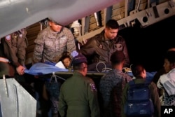 Military personnel unload from a plane one of four Indigenous brothers who were missing after a deadly plane crash at the military air base in Bogota, Colombia, June 10, 2023.