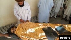 A relative attends to a man, who was injured in a bomb blast, after he was brought to a hospital for treatment in Hangu district, bordering North Waziristan, Pakistan, Oct. 3, 2013.
