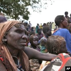 People wait at the food distribution center set up by the World Food Program in Gumuruk, 40 kilometers from Pibor, South Sudan, January 17, 2012.