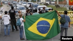 Residents from the Vila Autodromo favela block Abelardo Bueno avenue during a protest against construction work for the Rio 2016 Olympic Park in Rio de Janeiro, April 1, 2015.