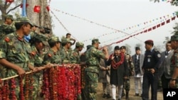 Maoist combatants greet Nepal's former Prime Minister Madhav Kumar Nepal at the Shaktikhor Maoist cantonment in Chitwan, about 80 kilometers (50 miles) southwest of Katmandu, 22 January 2011.