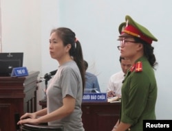 Prominent blogger Nguyen Ngoc Nhu Quynh, left, stands trial in the south central province of Khanh Hoa, Vietnam, June 29, 2017. She was accused of distorting government policies and defaming the Communist regime on her Facebook posts.