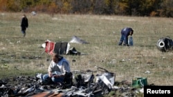 Members of a recovery team work at the site where downed Malaysia Airlines flight MH17 crashed, near the village of Hrabove, Donetsk region, eastern Ukraine, Oct. 13, 2014.